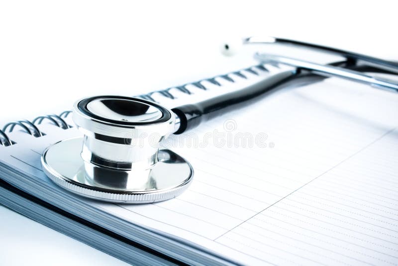 Medical stethoscope with blue tint on notebook stock images