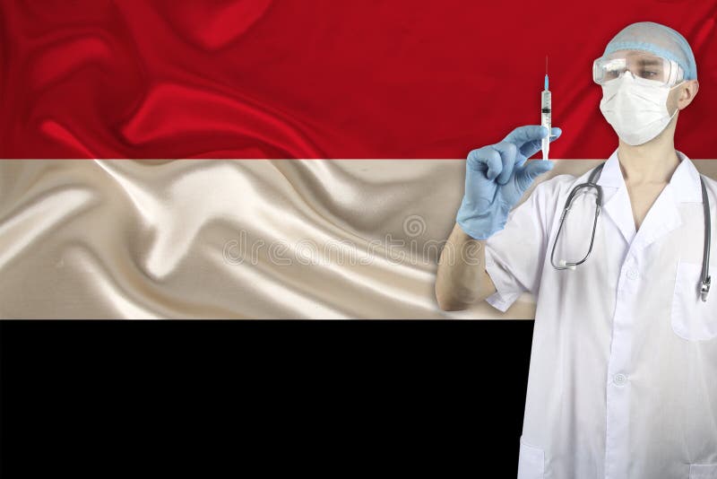 Medical syringe for injection in the hands of a doctor against the background of the yemen national flag, concept of the SARS stock photo Medical syringe for injection in the hands of a doctor against the background of the yemen national flag, concept of the SARS stock photo