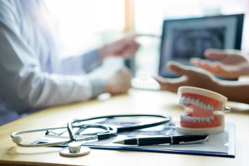 Medical team discussing, health care talking to female patient, Medical conferrence concept, doctor holding and looking at dental stock photography Medical team discussing, health care talking to female patient, Medical conferrence concept, doctor holding and looking at dental stock photography