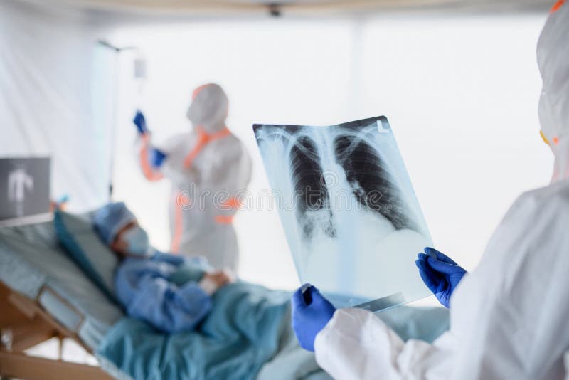 Medical team looking after infected patient in hospital, coronavirus concept. Medical team with x-ray looking after infected patient in hospital, coronavirus royalty free stock image Medical team looking after infected patient in hospital, coronavirus concept. Medical team with x-ray looking after infected patient in hospital, coronavirus royalty free stock image