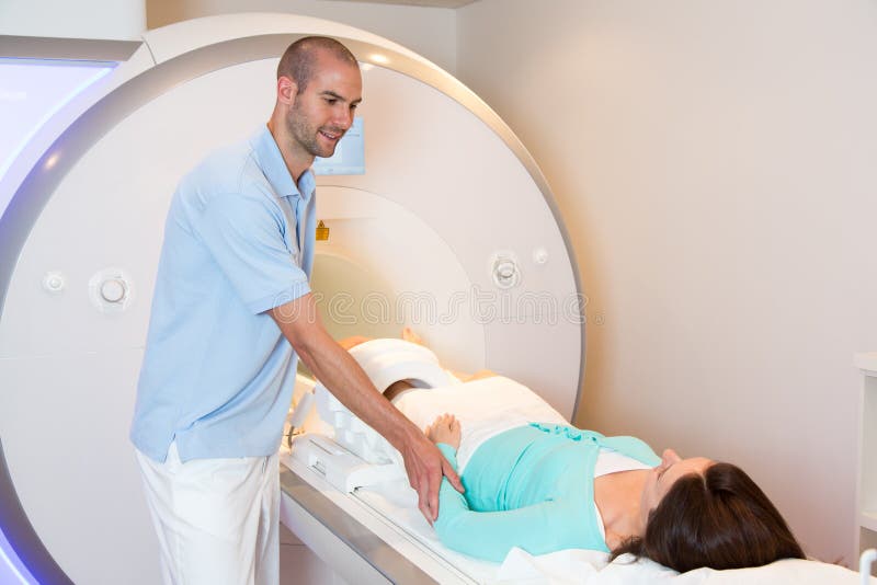 Medical technical assistant preparing scan of knee with MRI. Medical technical assistant councelling patient and preparing scan of the knee with magnetic stock photo Medical technical assistant preparing scan of knee with MRI. Medical technical assistant councelling patient and preparing scan of the knee with magnetic stock photo