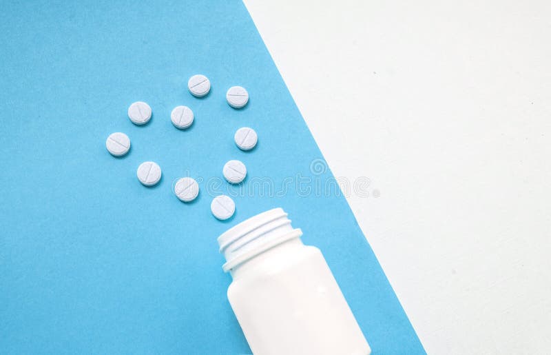 Medication Bottle And White Pills Spilled On Blue Pastel Colored Background Medication And