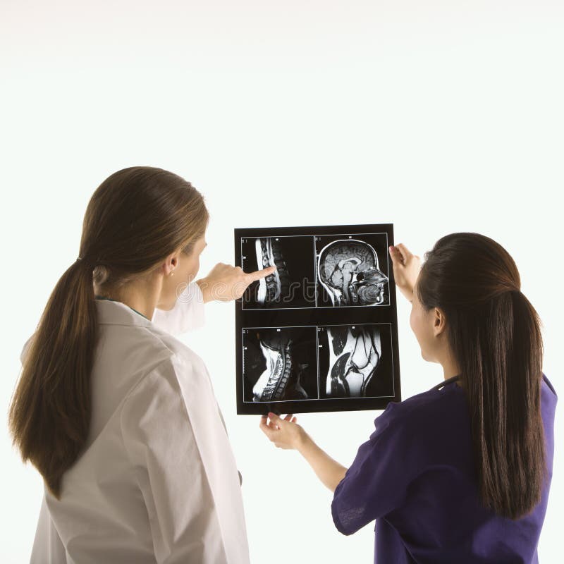 Medici che analizzano raggi X. fotografia stock libera da diritti Medici che analizzano raggi X. fotografia stock libera da diritti