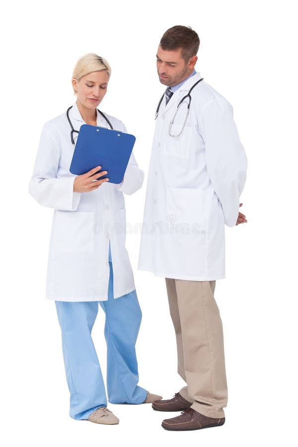 Medici che discutono qualcosa sulla lavagna per appunti immagini stock libere da diritti Medici che discutono qualcosa sulla lavagna per appunti immagini stock libere da diritti