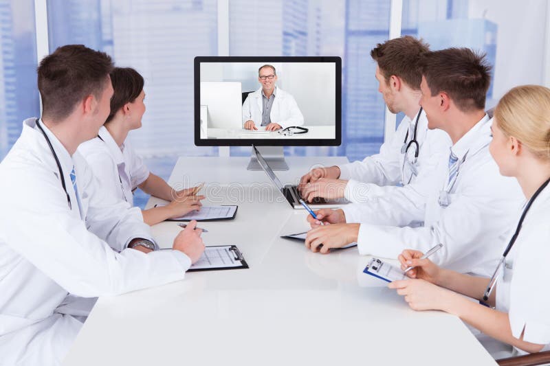 Medici che hanno riunione di videoconferenza in ospedale immagine stock libera da diritti Medici che hanno riunione di videoconferenza in ospedale immagine stock libera da diritti