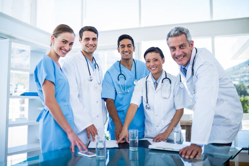 Medici ed infermieri che sorridono alla macchina fotografica fotografia stock libera da diritti Medici ed infermieri che sorridono alla macchina fotografica fotografia stock libera da diritti