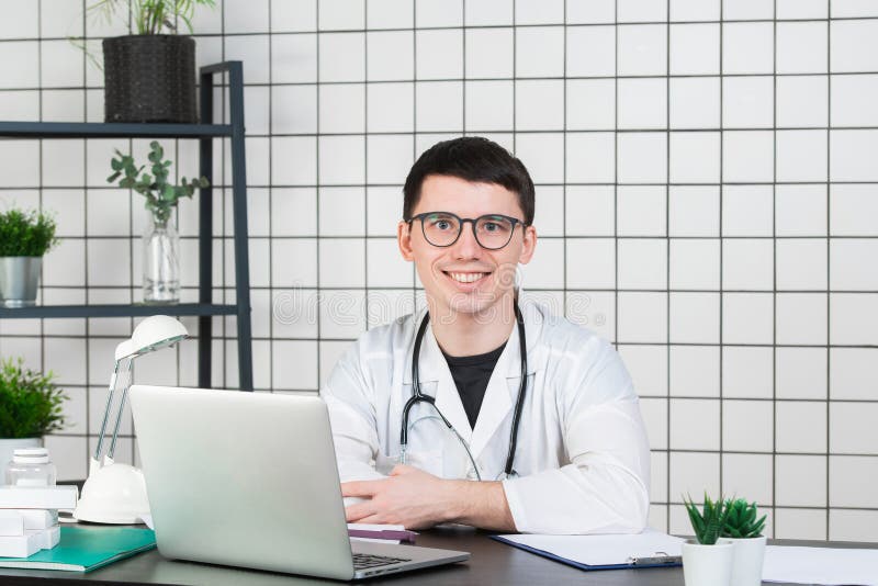 Medicin, yrke, teknologi och folkbegrepp - le den manliga doktorn med bärbara datorn i medicinskt kontor royaltyfria bilder Medicin, yrke, teknologi och folkbegrepp - le den manliga doktorn med bärbara datorn i medicinskt kontor royaltyfria bilder