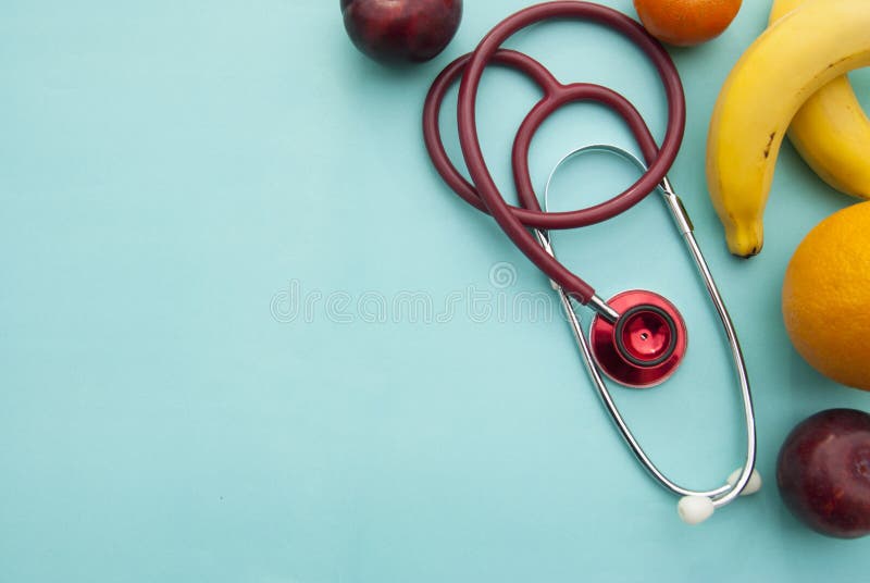 Medicine and healthcare, nutrition or medical insurance over blue background. Fruits and red sthetoscop. Copy space. stock photography Medicine and healthcare, nutrition or medical insurance over blue background. Fruits and red sthetoscop. Copy space. stock photography