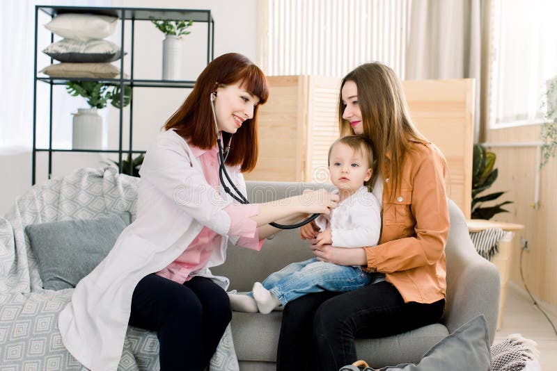 Medicine, healthcare, pediatry and people concept - Young woman Pediatrician checks breath stethoscope a little girl in stock photography Medicine, healthcare, pediatry and people concept - Young woman Pediatrician checks breath stethoscope a little girl in stock photography