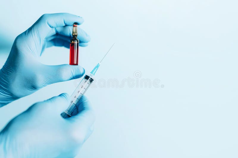 Medicine, injections and vaccination concept. Hands in medical gloves holding syringe and ampoule on blue background. Copy space.