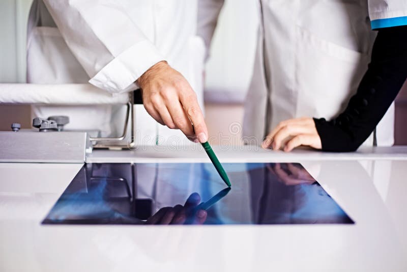 Medicine lab doctor pointing on x-ray with a nurse no face stock photography
