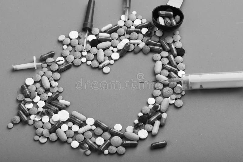 Medicine and love concept. Drugs near syringes, pipette and measuring spoon. Set of colorful pills scattered on pink background, copy space. Frame made of pills and capsules put in shape of heart. Medicine and love concept. Drugs near syringes, pipette and measuring spoon. Set of colorful pills scattered on pink background, copy space. Frame made of pills and capsules put in shape of heart.