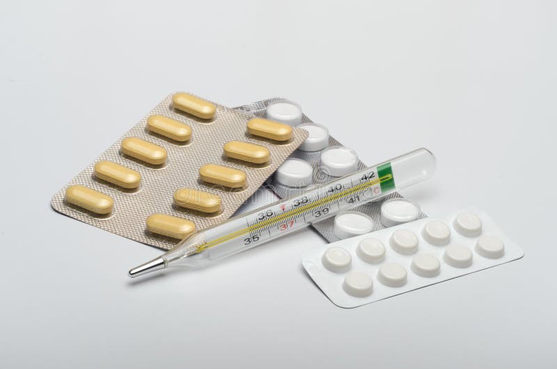 Mediciner med en termometer, minnestavlor mot virus- sjukdomar arkivfoton Mediciner med en termometer, minnestavlor mot virus- sjukdomar arkivfoton
