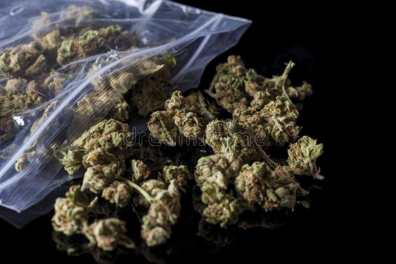 Medicinska cannabisknoppar spridde från packen på svart från sida arkivfoton Medicinska cannabisknoppar spridde från packen på svart från sida arkivfoton
