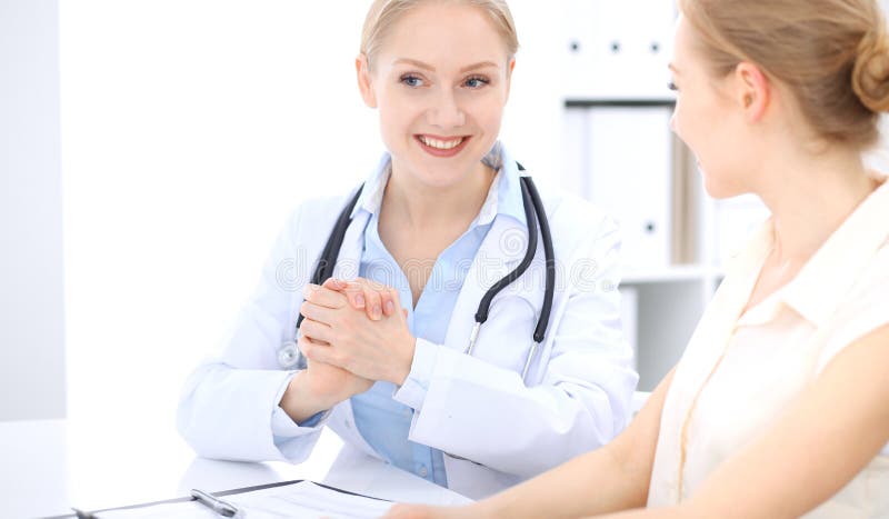 Medico biondo e paziente femminili che parlano nell'ufficio dell'ospedale Sanità e servizio del cliente nella medicina immagini stock libere da diritti Medico biondo e paziente femminili che parlano nell'ufficio dell'ospedale Sanità e servizio del cliente nella medicina immagini stock libere da diritti