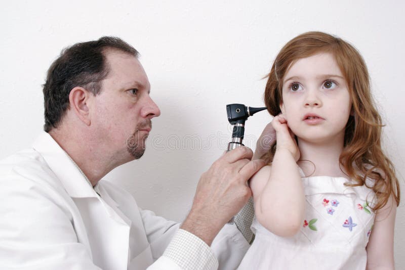Medico che controlla l'orecchio della bambina