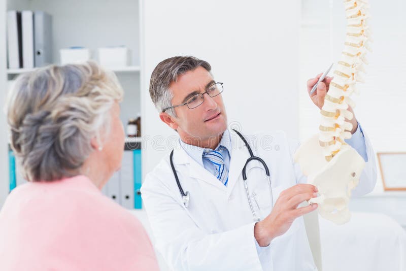 Medico che explaning spina dorsale anatomica alla donna senior immagine stock Medico che explaning spina dorsale anatomica alla donna senior immagine stock