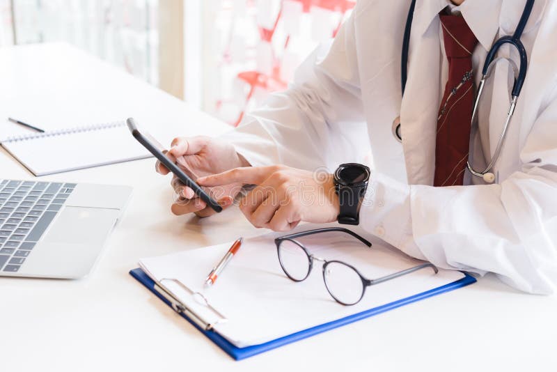 Medico che lavora allo smartphone immagine stock Medico che lavora allo smartphone immagine stock