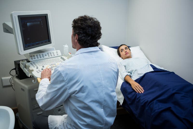 Medico che per mezzo della macchina di ecografia immagine stock libera da diritti Medico che per mezzo della macchina di ecografia immagine stock libera da diritti
