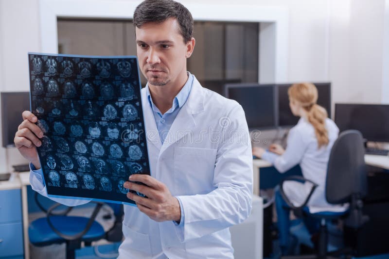 Medico con esperienza bello che mette una diagnosi immagine stock libera da diritti Medico con esperienza bello che mette una diagnosi immagine stock libera da diritti