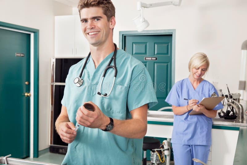 Medico con la siringa mentre infermiera che cattura giù il rapporto fotografie stock libere da diritti Medico con la siringa mentre infermiera che cattura giù il rapporto fotografie stock libere da diritti