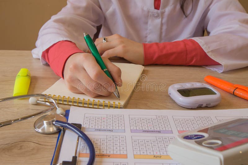 Medico con lo stetoscopio che si siede ad uno scrittorio, scrivente qualcosa, prescrizione o raccomandazione del paziente, la fot fotografie stock libere da diritti Medico con lo stetoscopio che si siede ad uno scrittorio, scrivente qualcosa, prescrizione o raccomandazione del paziente, la fot fotografie stock libere da diritti
