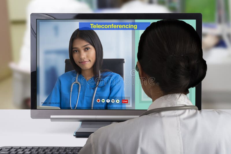 Medico di due femmine facendo uso di tecnologia di teleconferenza al discutsion circa il caso paziente