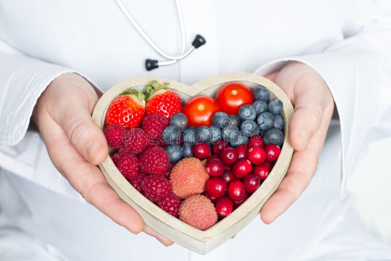 Medico e lo stetoscopio con l'alimento di dieta sana del cuore sottraggono il concetto della medicina immagine stock Medico e lo stetoscopio con l'alimento di dieta sana del cuore sottraggono il concetto della medicina immagine stock