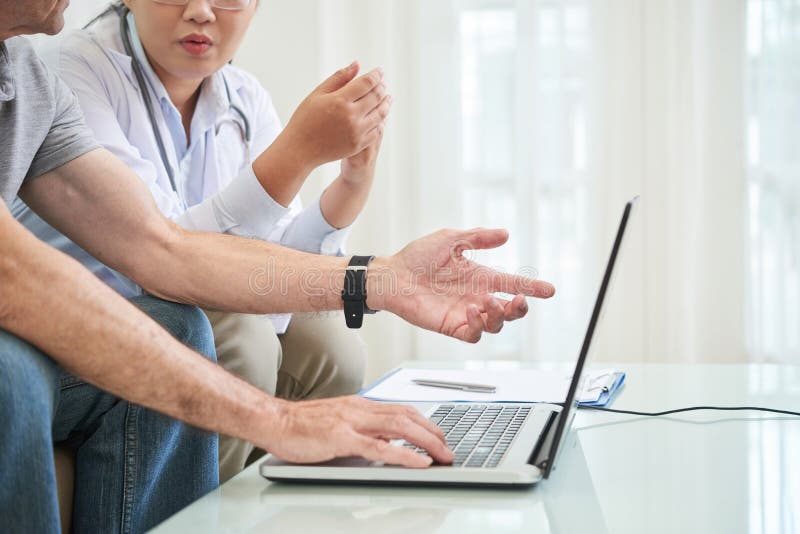Medico e paziente che discutono i risultati delle prove immagini stock libere da diritti Medico e paziente che discutono i risultati delle prove immagini stock libere da diritti