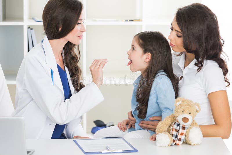 Medico esamina la gola del ` s del bambino fotografia stock