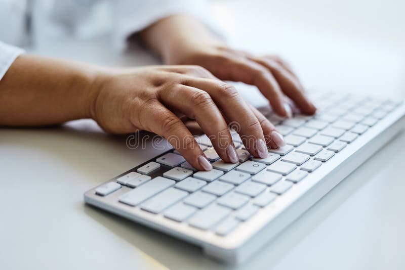 Medico femminile che scrive sulla tastiera nell'ufficio fotografie stock libere da diritti Medico femminile che scrive sulla tastiera nell'ufficio fotografie stock libere da diritti