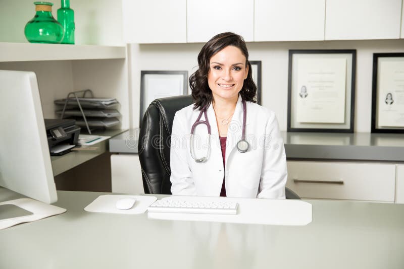 Medico femminile ispano grazioso in un ufficio immagine stock libera da diritti Medico femminile ispano grazioso in un ufficio immagine stock libera da diritti