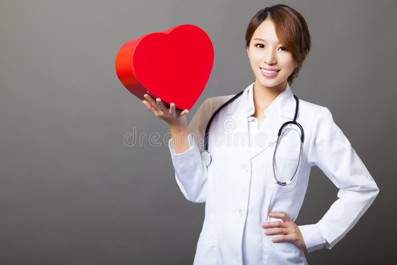 Medico femminile sorridente con cuore immagine stock libera da diritti Medico femminile sorridente con cuore immagine stock libera da diritti