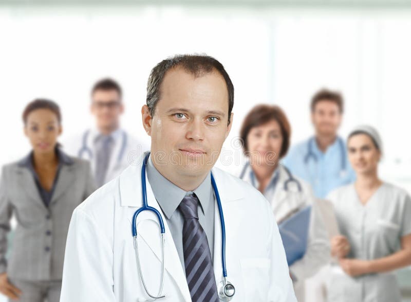 Medico maschio sicuro davanti al gruppo di medici fotografie stock libere da diritti Medico maschio sicuro davanti al gruppo di medici fotografie stock libere da diritti
