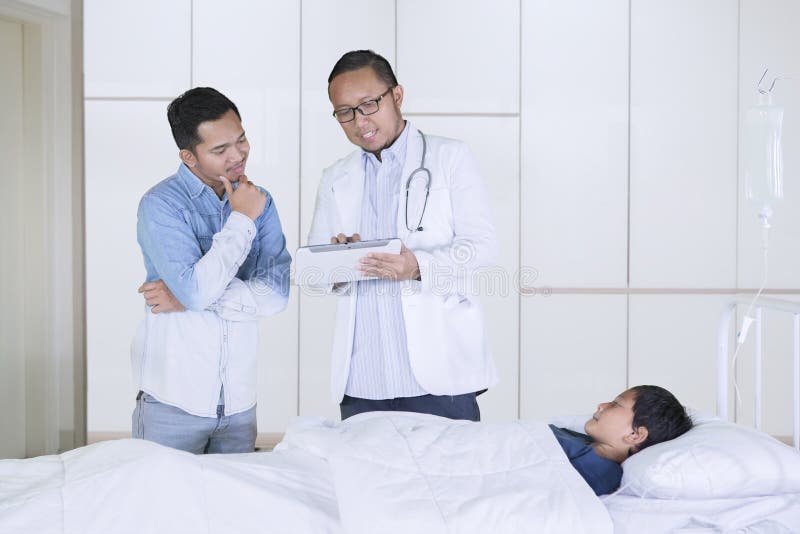 Medico maschio spiega il risultato medico sul padre fotografia stock libera da diritti Medico maschio spiega il risultato medico sul padre fotografia stock libera da diritti
