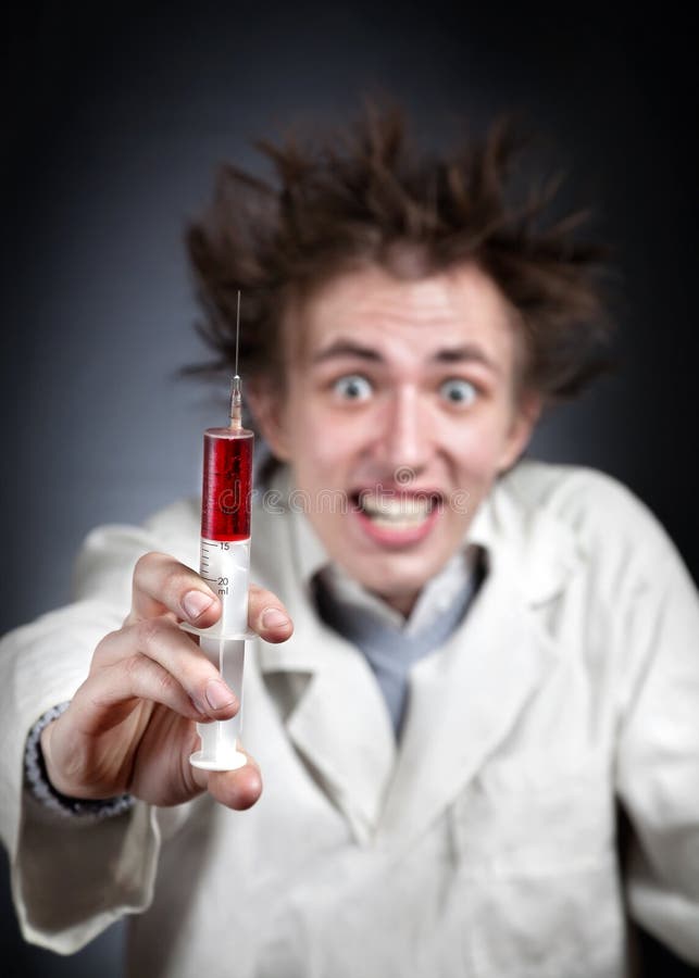 Crazy doctor holding syringe with red liquid and smiling. Crazy doctor holding syringe with red liquid and smiling