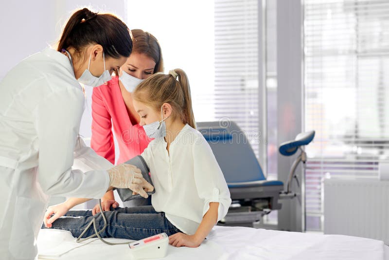 Medico professionista che misura la pressione sanguigna della ragazza usando il tonometro fotografia stock libera da diritti