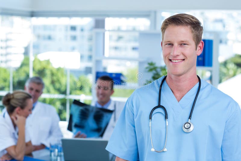 Medico sorridente bello che esamina macchina fotografica immagini stock Medico sorridente bello che esamina macchina fotografica immagini stock