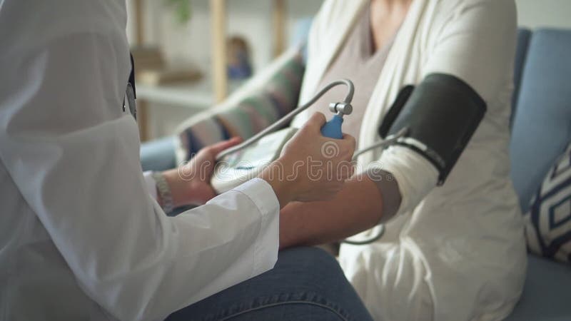 Medico sta prendendo la pressione sanguigna di ricerca e di misurazione di ultrasuono dal paziente anziano facendo uso di monitor