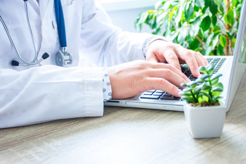 Medicul sau asistenta care tastează pe tastatura laptopului sau care caută informații necesare online pentru a completa polița de royalty free stock photography