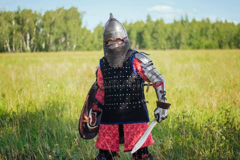 A medieval Central Asian warrior a nomad in 14th-century armor stands in a defensive or attacking position royalty free stock image
