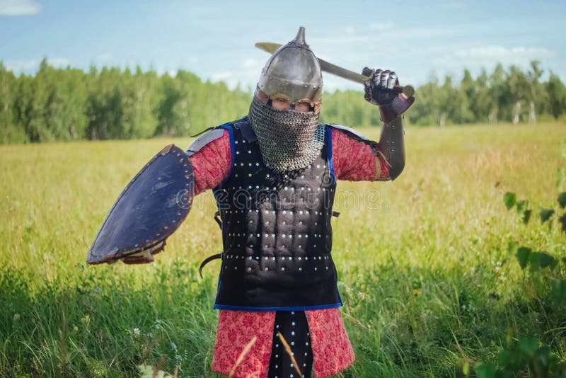 A medieval Central Asian warrior a nomad in 14th-century armor stands in a defensive or attacking position royalty free stock photo