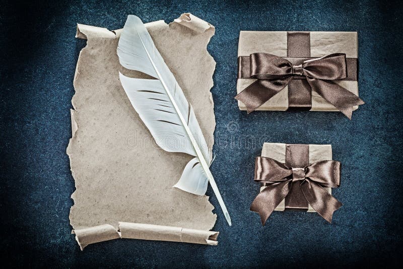 Medieval paper scroll plume gift boxes on black background stock image