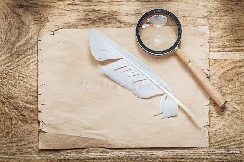 Medieval parchment magnifier plume on wooden board royalty free stock image