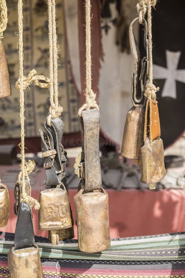 Metal and brass cowbells hanging in a medieval stall