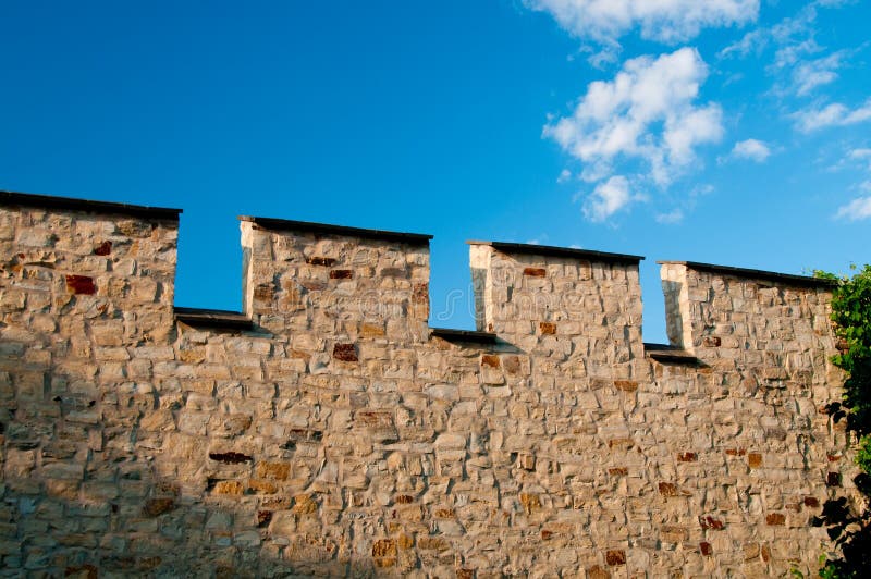 Medieval stone wall against blue sky royalty free stock photography