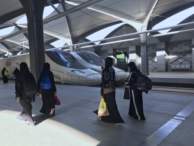 MEDINA, LA ARABIA SAUDITA - 27 DE MAYO DE 2019: un grupo de mujeres en los abayas negros listos para embarcar los coches del tren