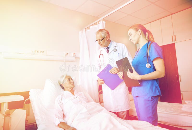 Medique e nutra a mulher superior de visita no hospital foto de stock Medique e nutra a mulher superior de visita no hospital foto de stock