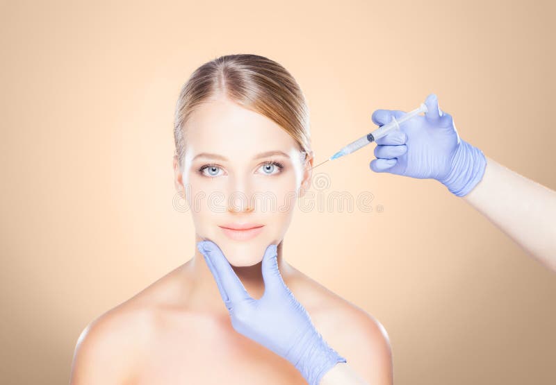 Medique a injeção em uma cara bonita de uma jovem mulher Plástico s fotos de stock royalty free Medique a injeção em uma cara bonita de uma jovem mulher Plástico s fotos de stock royalty free
