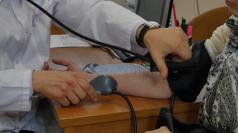 Medique medidas de pressão sanguínea arterial do paciente da menina pelo tonometer na clínica